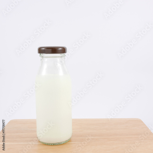 The bottle of fresh milk on the wooden board.