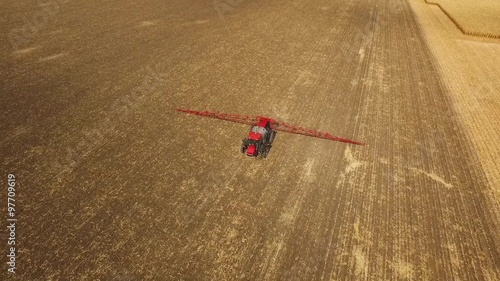 Tractor sprays which protect against pests at a farmer's field corn, aerial shot