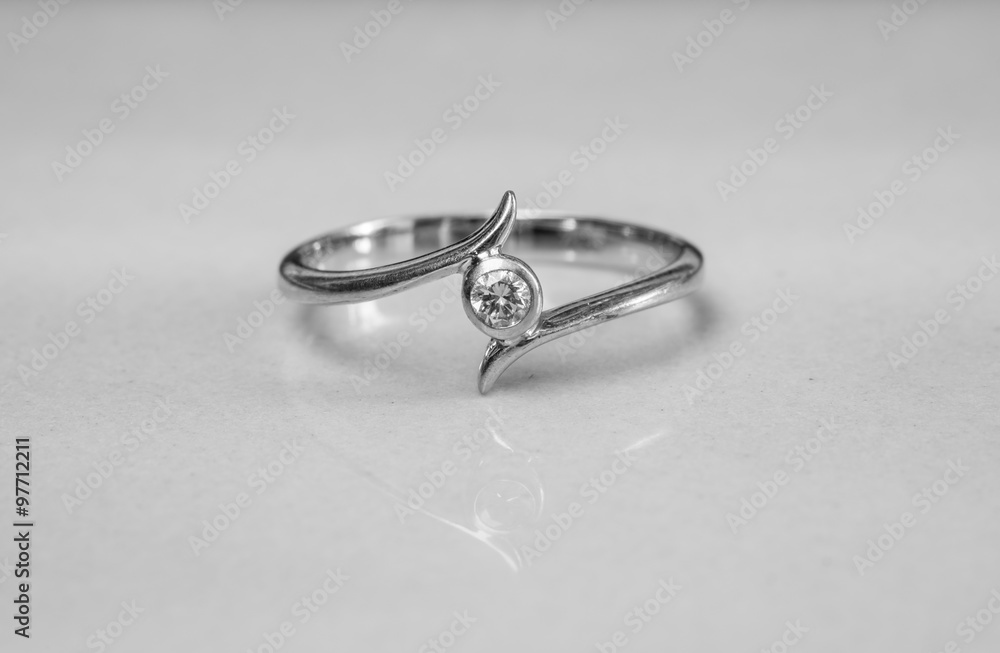 Closeup old diamond ring on blurred marble floor background in black and white tone Closeup old diamond ring on blurred marble floor background in black and white tone
