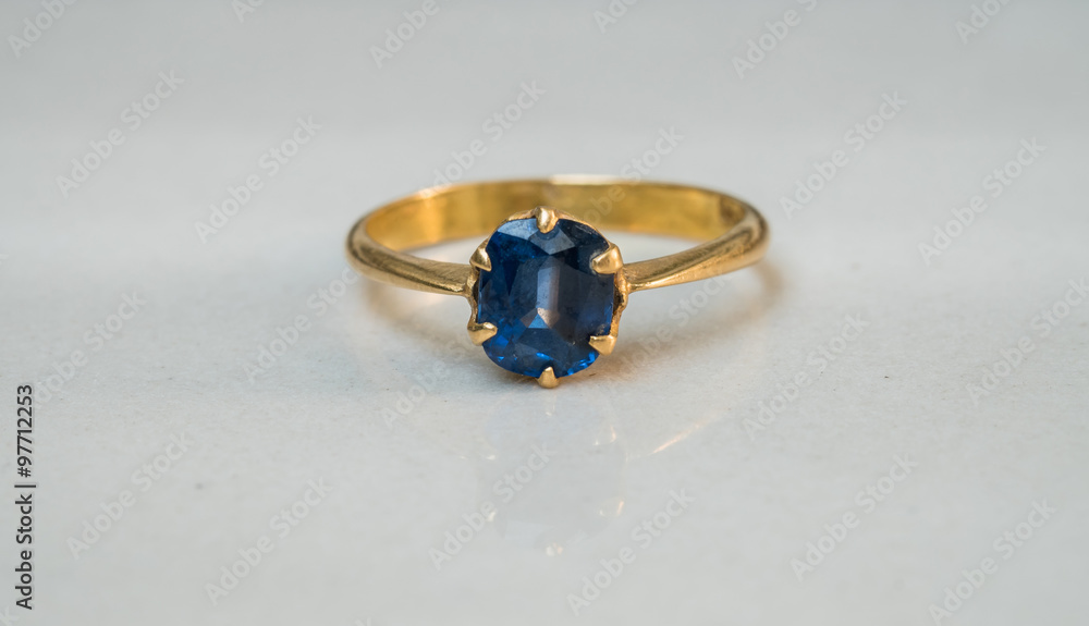 Closeup blue pebble ring on blurred marble floor background in black and white tone Closeup blue pebble ring on blurred marble floor background in black and white tone