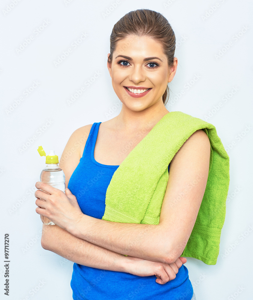 smiling sporty woman studio portrait with water bottle, towel.