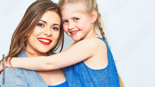 studio isolated portrait of hugging mother and daughter