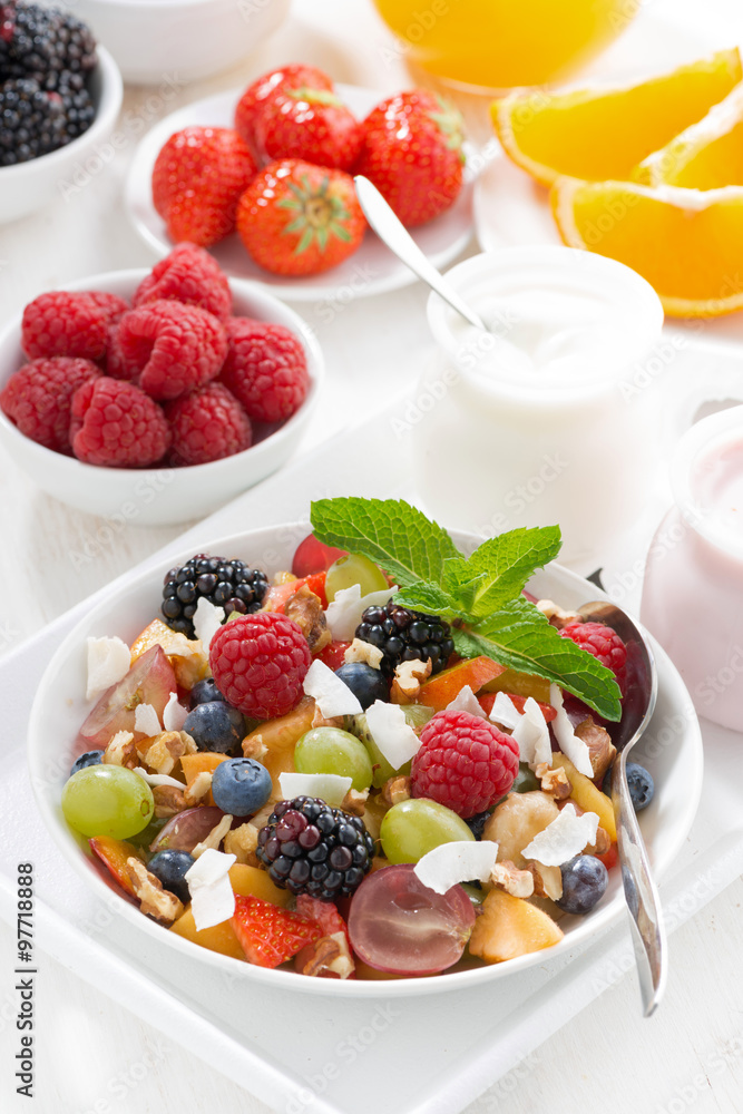fruit salad in a bowl and various yoghurt, top view fruit salad in a bowl and various yoghurt, top view