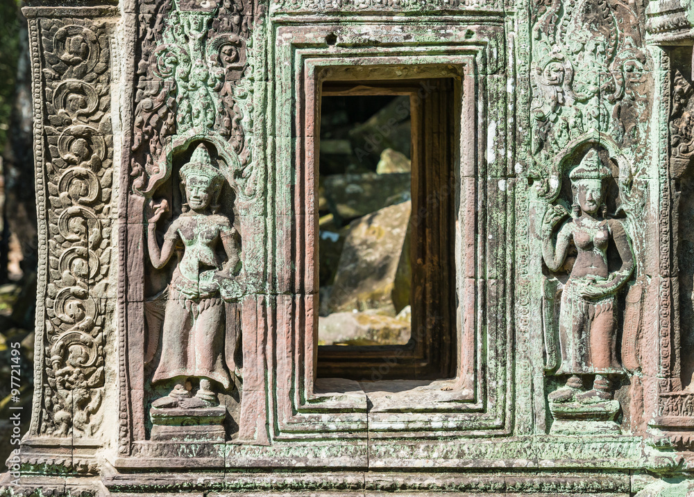 Beautifully decorated ancient khmer window with two apsara sculptures in Angkor Wat temple, Cambodia