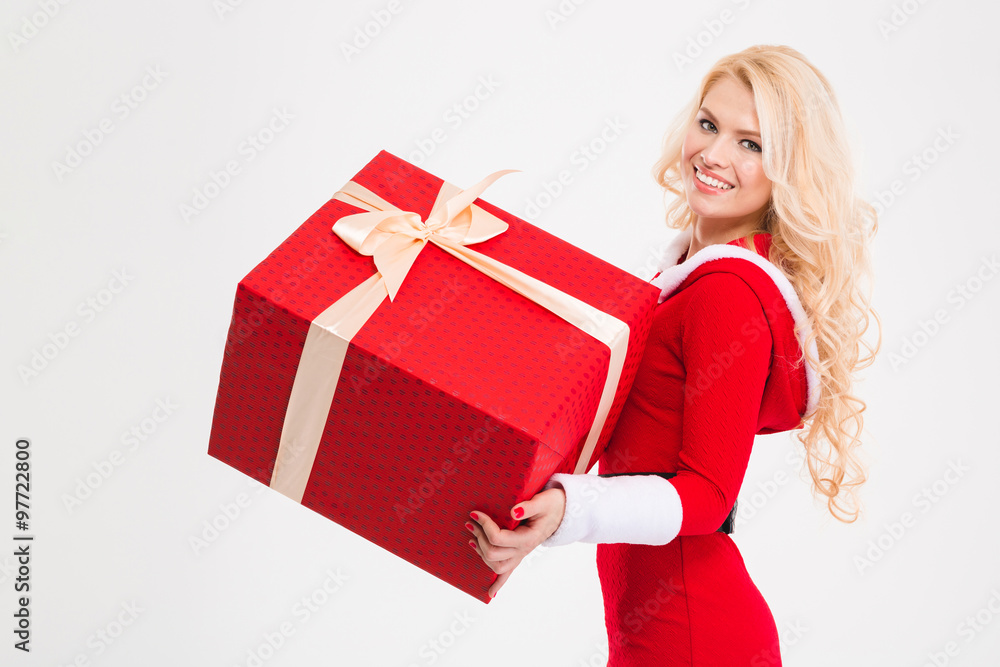 Cheerful female in santa claus clothes holding big red present Cheerful female in santa claus clothes holding big red present