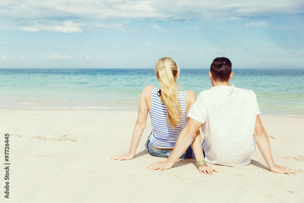Romantic young couple sitting on the beach Romantic young couple sitting on the beach