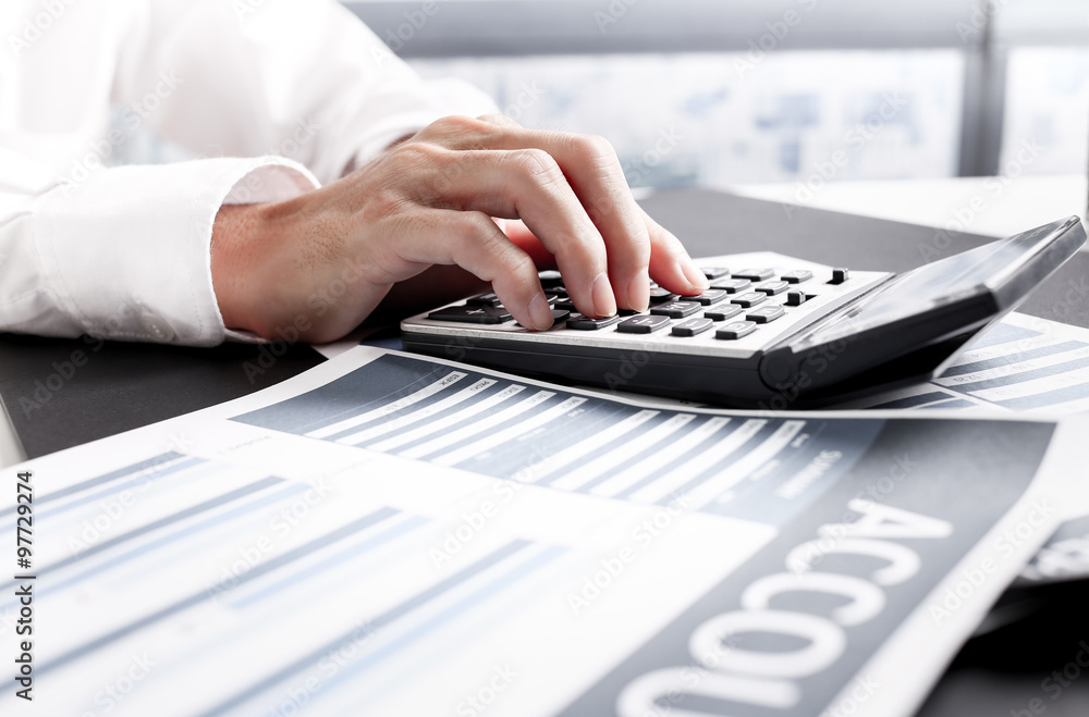 Businessman using a calculator to calculate the numbers. Account Businessman using a calculator to calculate the numbers. Account