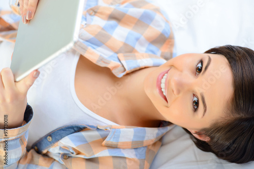 Smiling teenage girl with portable tablet.