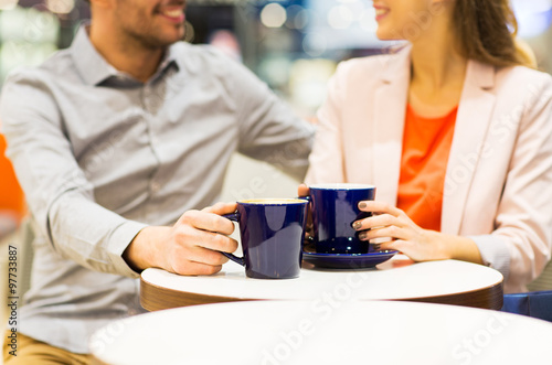 close up of happy couple drinking coffee in mall