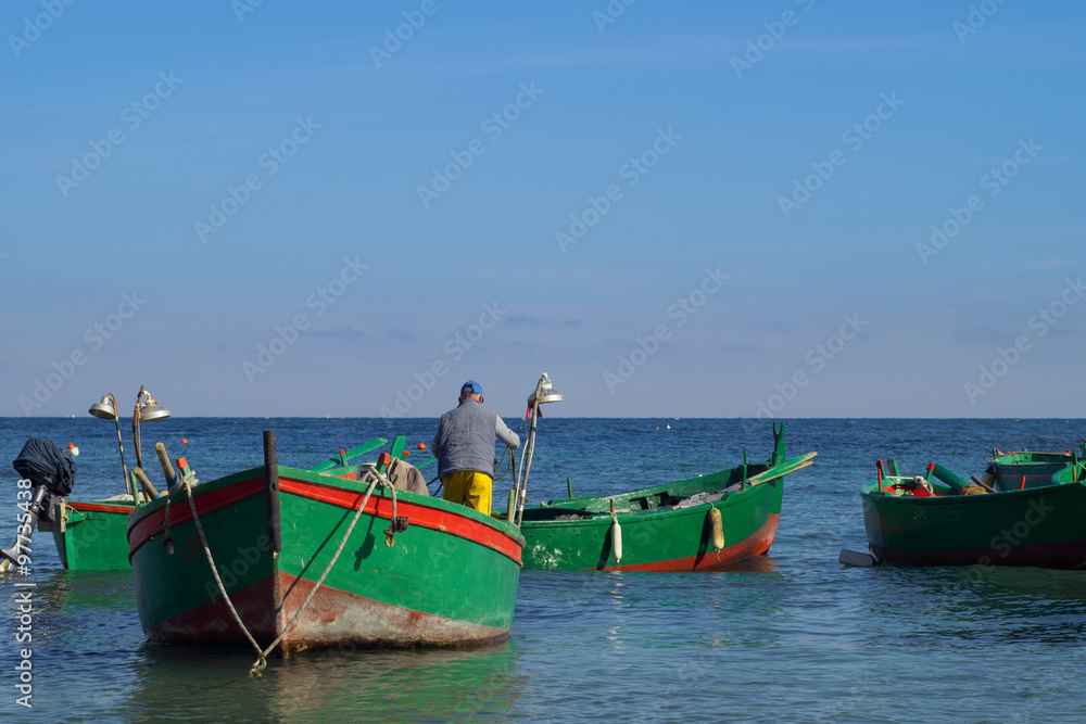 Fisher on a row boat in the harbor of Polignano a Mare - Apulia, Italy