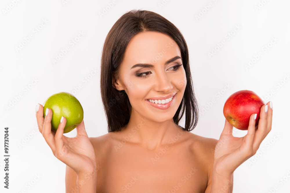 Good-looking bonny girl chosing between green and red apples Good-looking bonny girl chosing between green and red apples