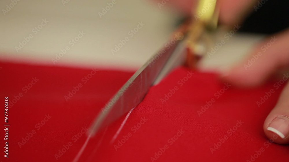 Slow motion of woman hands with scissors cutting red fabric on a tabletop. Designer scissor cloth. Slow motion of woman hands with scissors cutting red fabric on a tabletop. Designer scissor cloth.