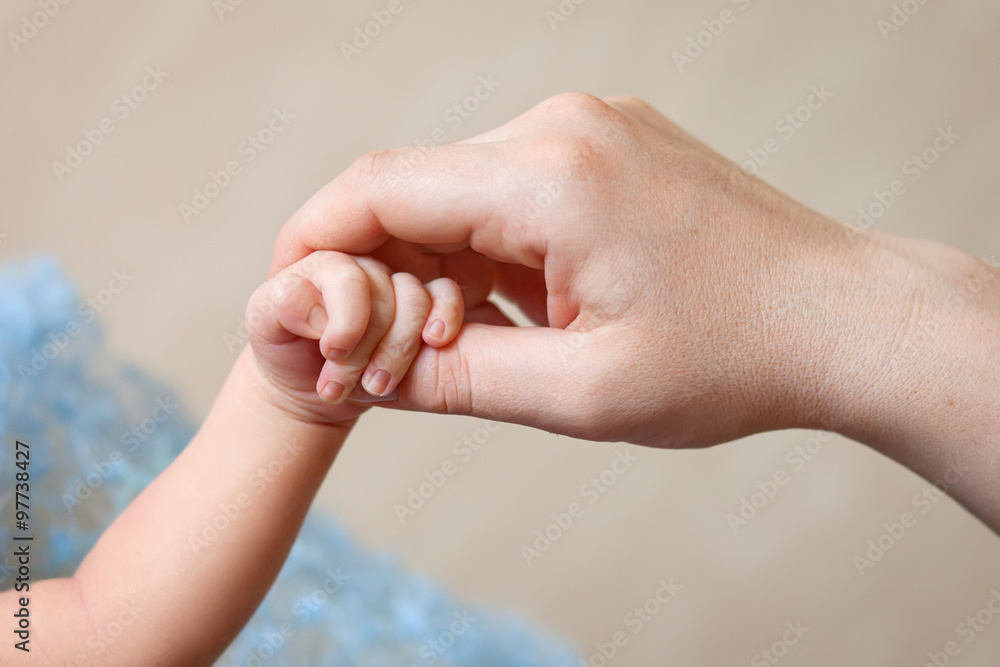 Newborn children's hand in mother hand. Mom and her Child. Happy Newborn children's hand in mother hand. Mom and her Child. Happy