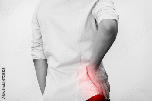 Young man in casual office shirt having hip pain (Selective Focus) photo