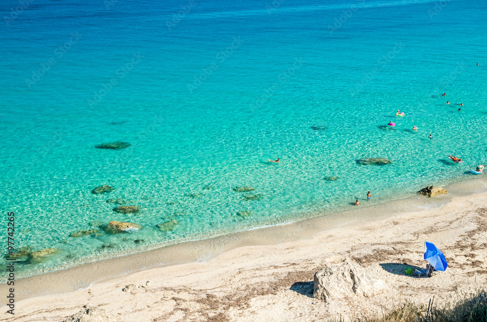 Obraz premium Agios Nikitas beach in Lefkada Island, Greece - Ionian Islands. In the background it is visible the village of Agios Nikitas. The beach is near the village of Agios Nikitas.