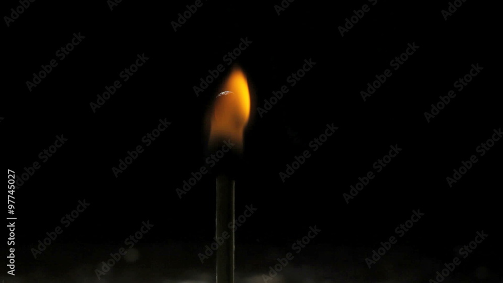 A match lights on a dark black background A match lights on a dark black background