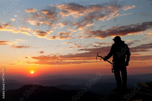 view of man on mountains with ice axe in hand