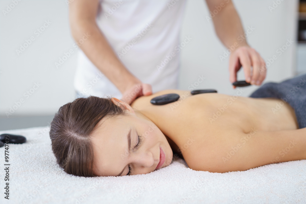 frau entspannt bei einer hot stone massage frau entspannt bei einer hot stone massage
