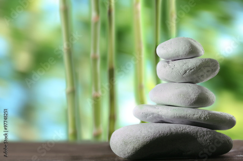 Spa stones on table   on green nature background