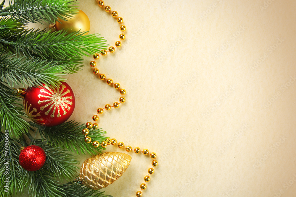 Christmas fir tree branches with toys and beads on paper background Christmas fir tree branches with toys and beads on paper background