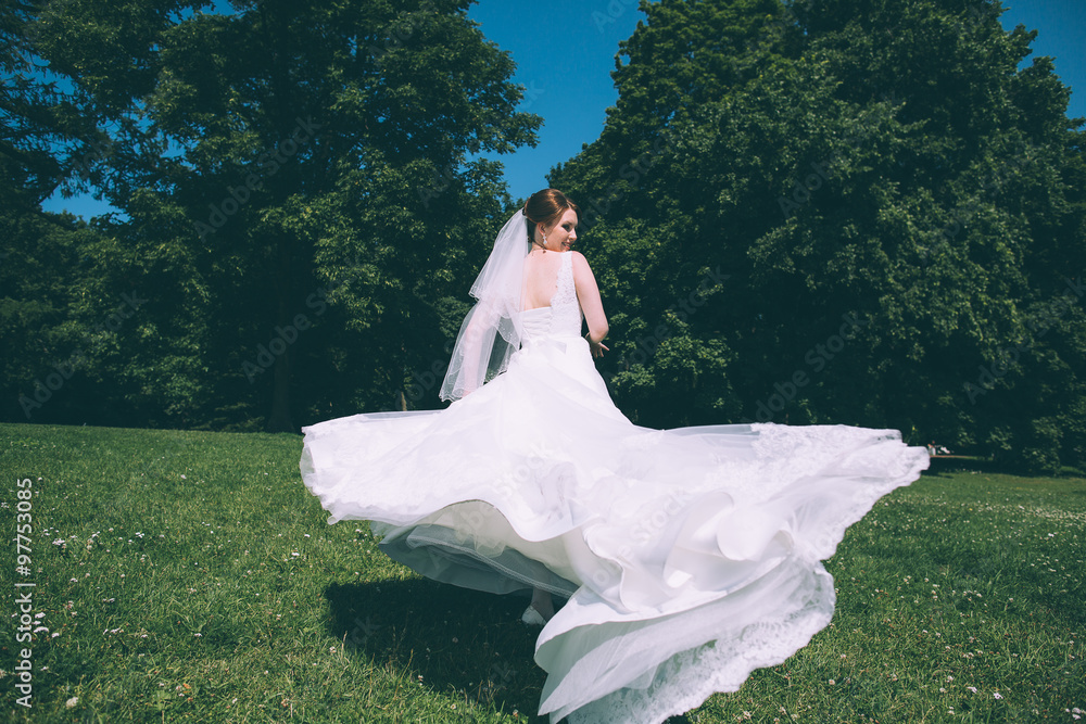 Beautiful young bride in a magnificent wedding dress spinning in nature, happiness, fun Beautiful young bride in a magnificent wedding dress spinning in nature, happiness, fun