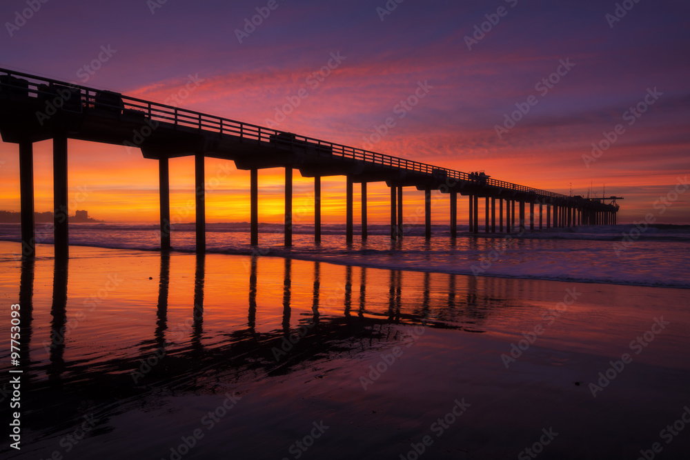 Silhouette pier at beach and brilliant sunset