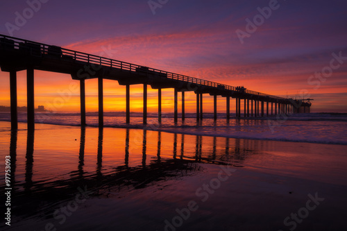 Silhouette pier at beach and brilliant sunset © Shakzu