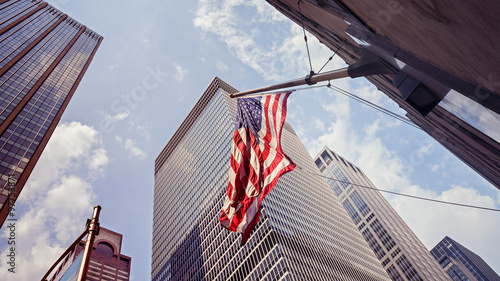 Vintage toned American flag and skyscrapers in NYC.