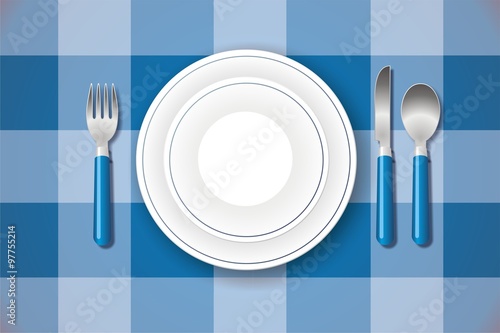 Platos y cubiertos sobre mantel de cuadros azules