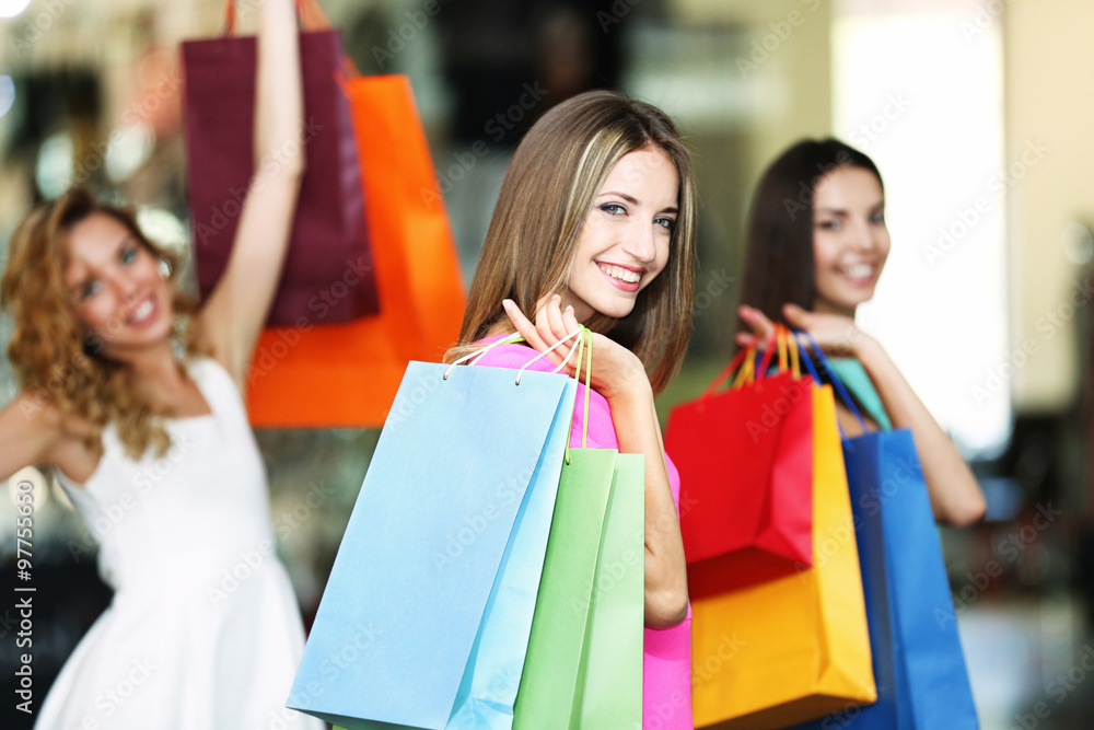Beautiful young women with bags in shopping center Beautiful young women with bags in shopping center
