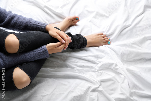 Woman in black jeans on bed top view point