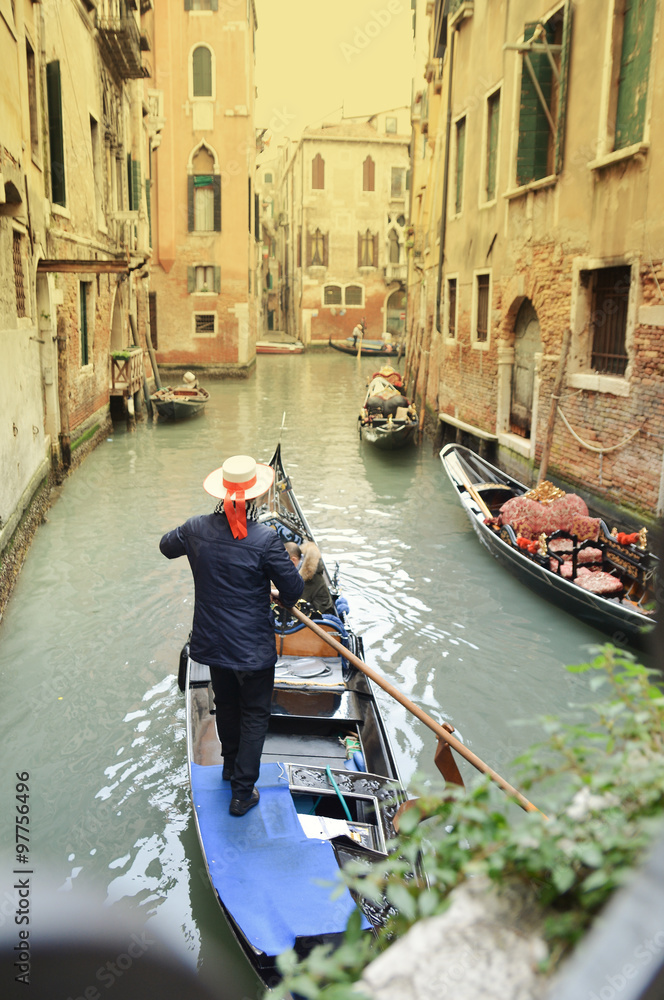 Vintage image of a gondolier on the canal in Venice city, Italy