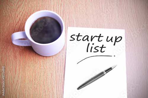 Coffee on the table with note writing start up list
