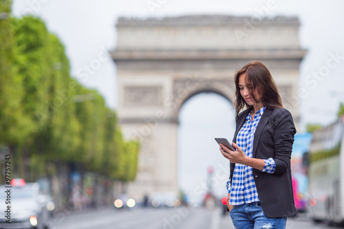 Photography Beautiful woman holding a phone on the Champs Elysees in Paris