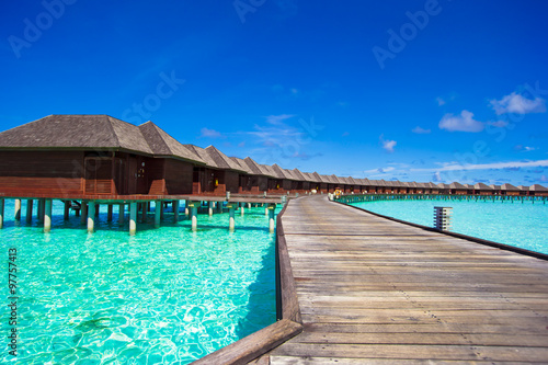 Water bungalows and wooden jetty on tropical island in Indian Ocean © travnikovstudio