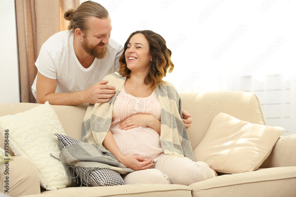 Handsome man takes care about his lovely pregnant woman