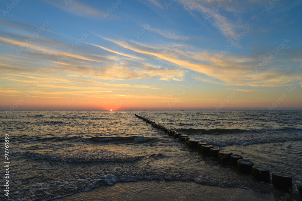 Naklejka premium Ostsee mit Buhnen, blauer Himmel kurz vor Sonnenaufgang