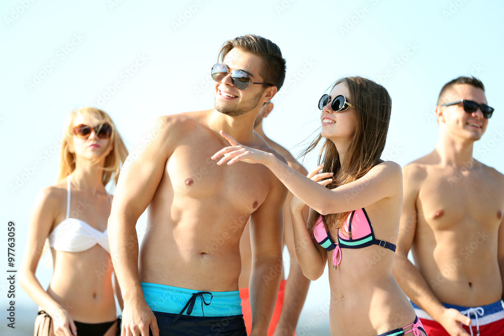 Happy young friends relaxing at the beach, outdoors Happy young friends relaxing at the beach, outdoors