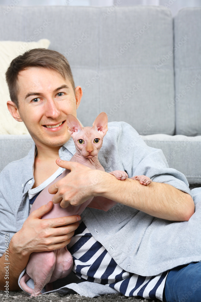 Young handsome man lies with cat on floor at home Young handsome man lies with cat on floor at home