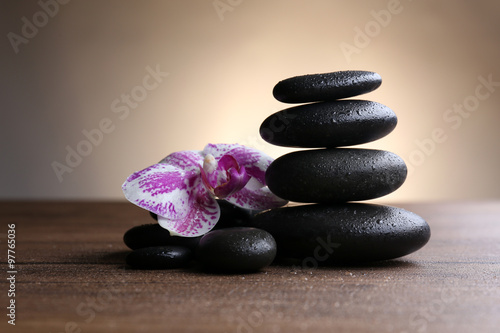 Black pebbles with orchid on wooden table