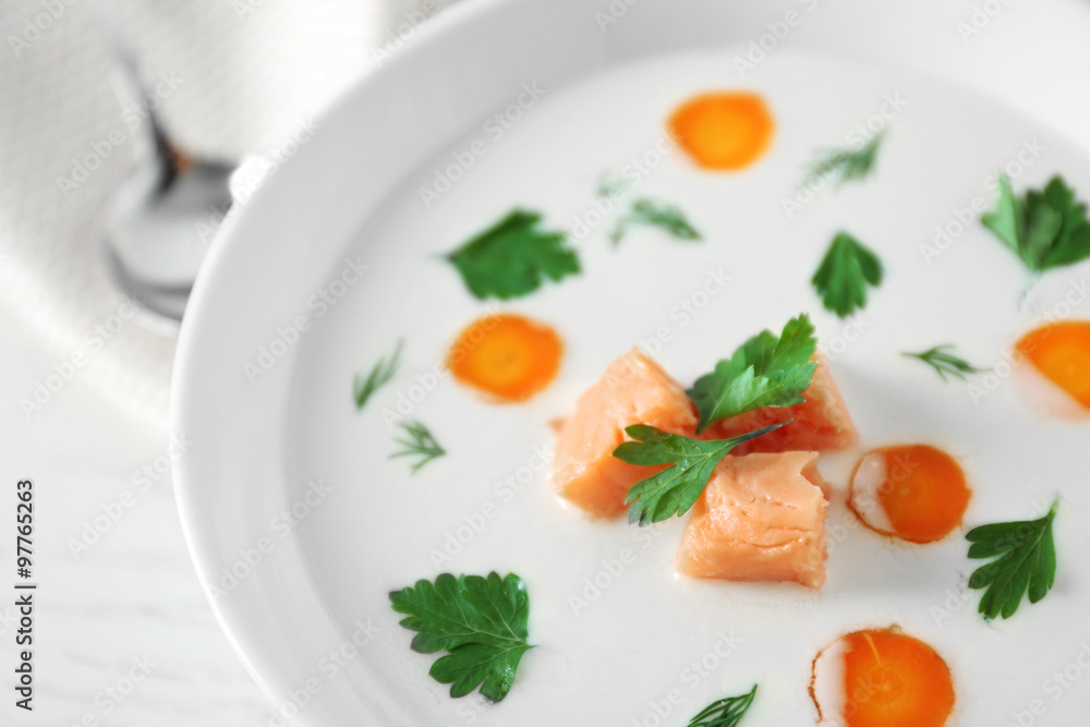 Delicious cream soup with salmon and carrot in white bowl Delicious cream soup with salmon and carrot in white bowl