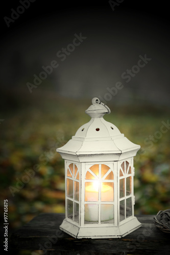 Lantern with candle on bench, on mountains background © Africa Studio
