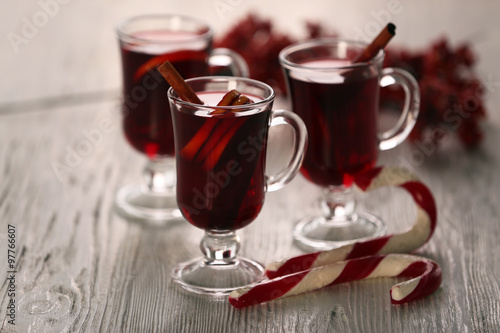 Mulled wine with cookies on wooden table