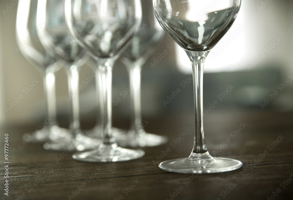 Empty wine glasses on wooden table against blurred background Empty wine glasses on wooden table against blurred background