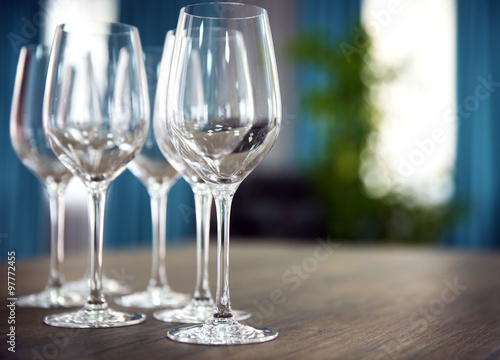 Empty wine glasses on wooden table against blurred background