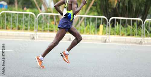 Marathon runner running on city road © lzf