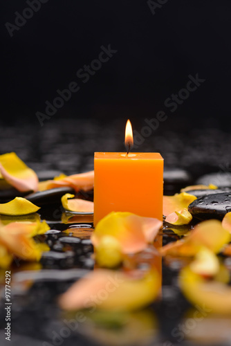 Set of orange rose petals with candle and therapy stones 