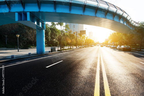 sunlight and empty road through bridge