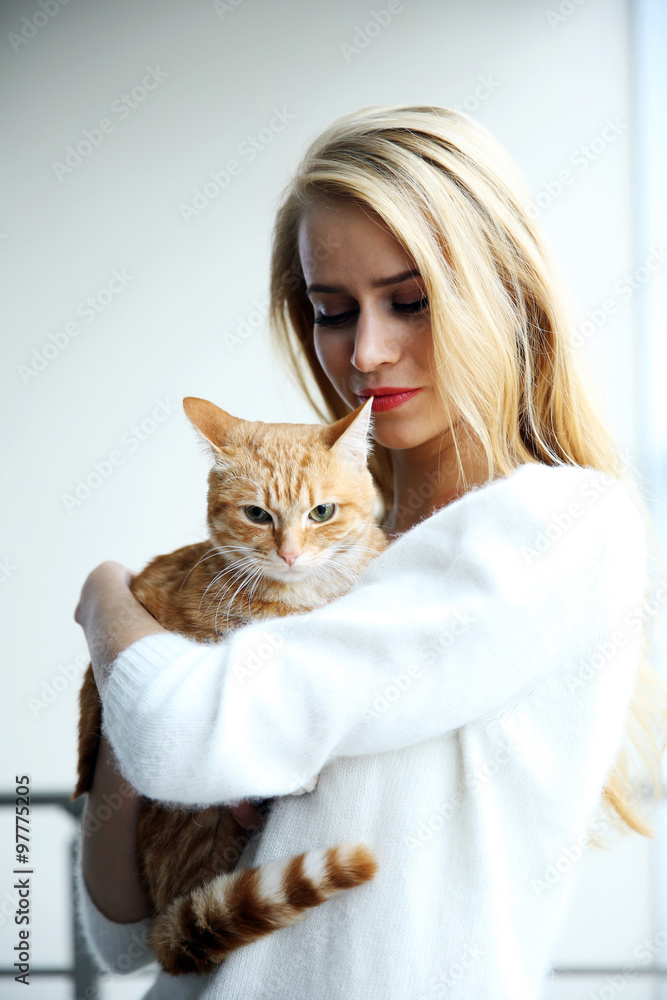 Young woman holds red cat in hands, close up Young woman holds red cat in hands, close up