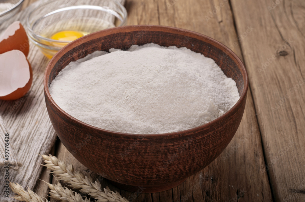 Flour in a clay bowl with ears of wheat Flour in a clay bowl with ears of wheat